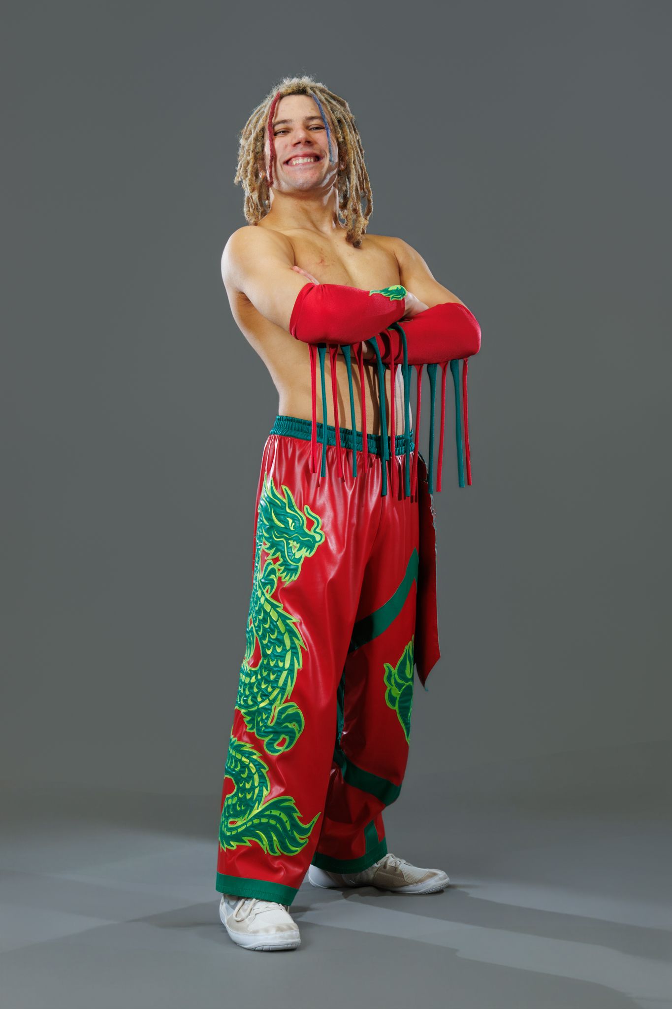 Jesse Dragonheart posing in red and green dragon-themed wrestling gear