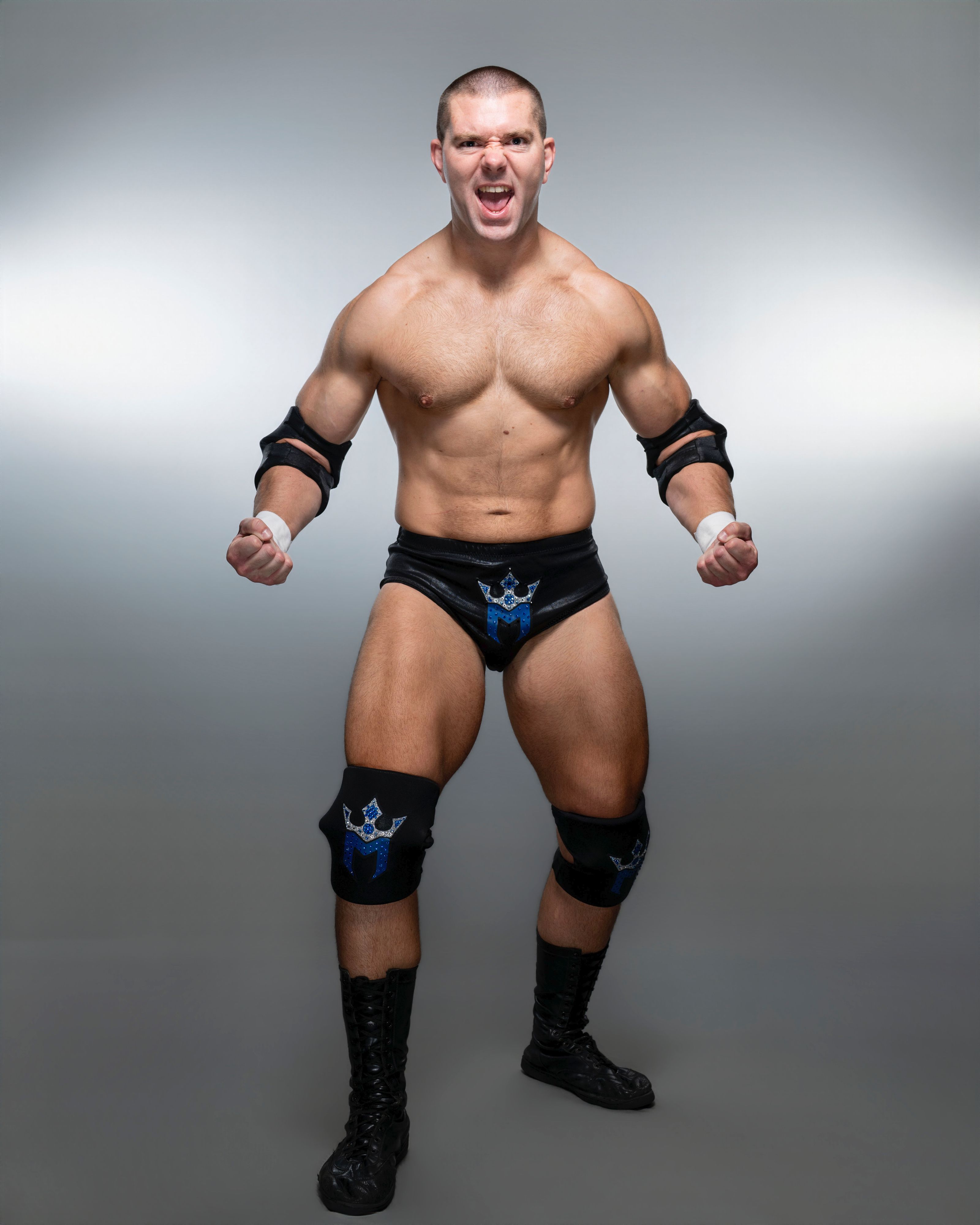 "The Strength Warrior" Mathias flexing and roaring in his black and blue wrestling gear