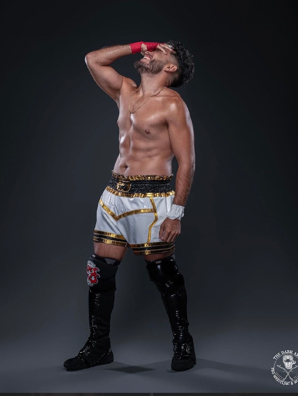 "The Tru Champion" Andres Reyes posing in white and gold trunks and black knee pads