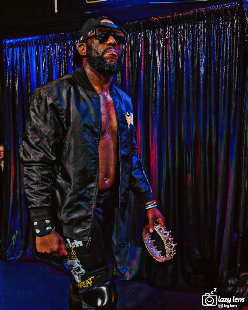 Skrilla The Great posing backstage with a championship belt