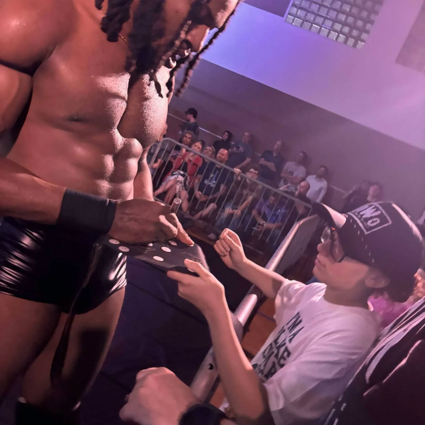 Trick Williams signing a championship belt for Trystan at a live NXT event