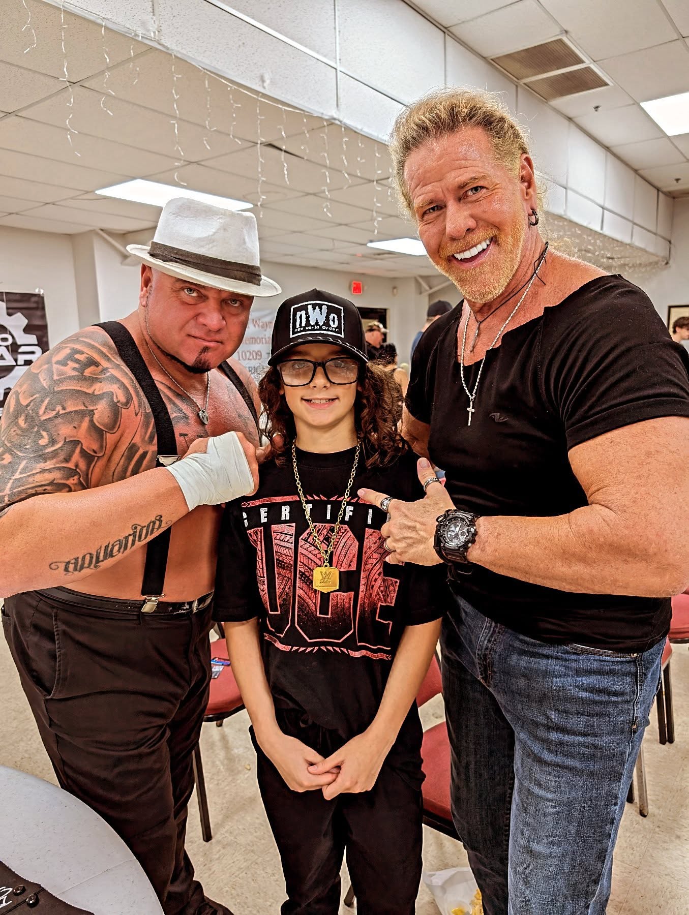 Trystan poses with wrestling legends at an event